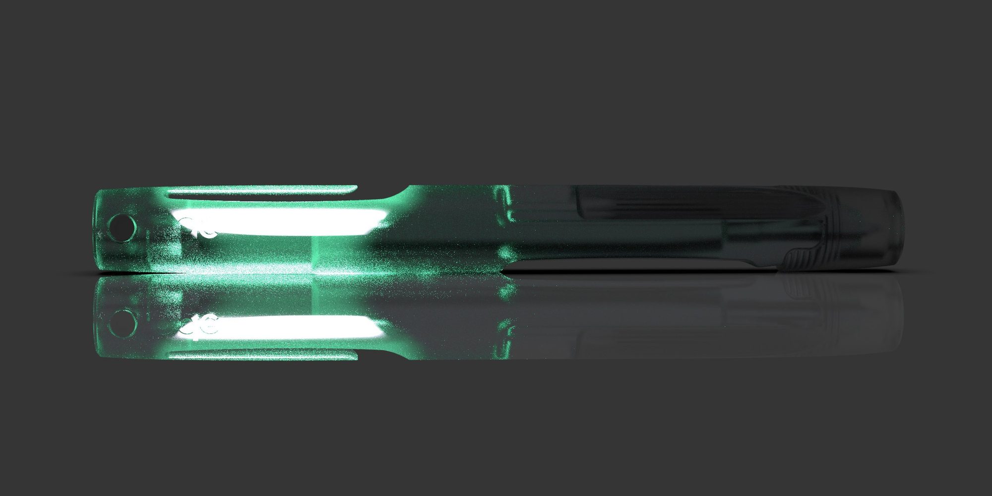 The Ode Pen in the dark, light glowing through the emerald resin at the tag end